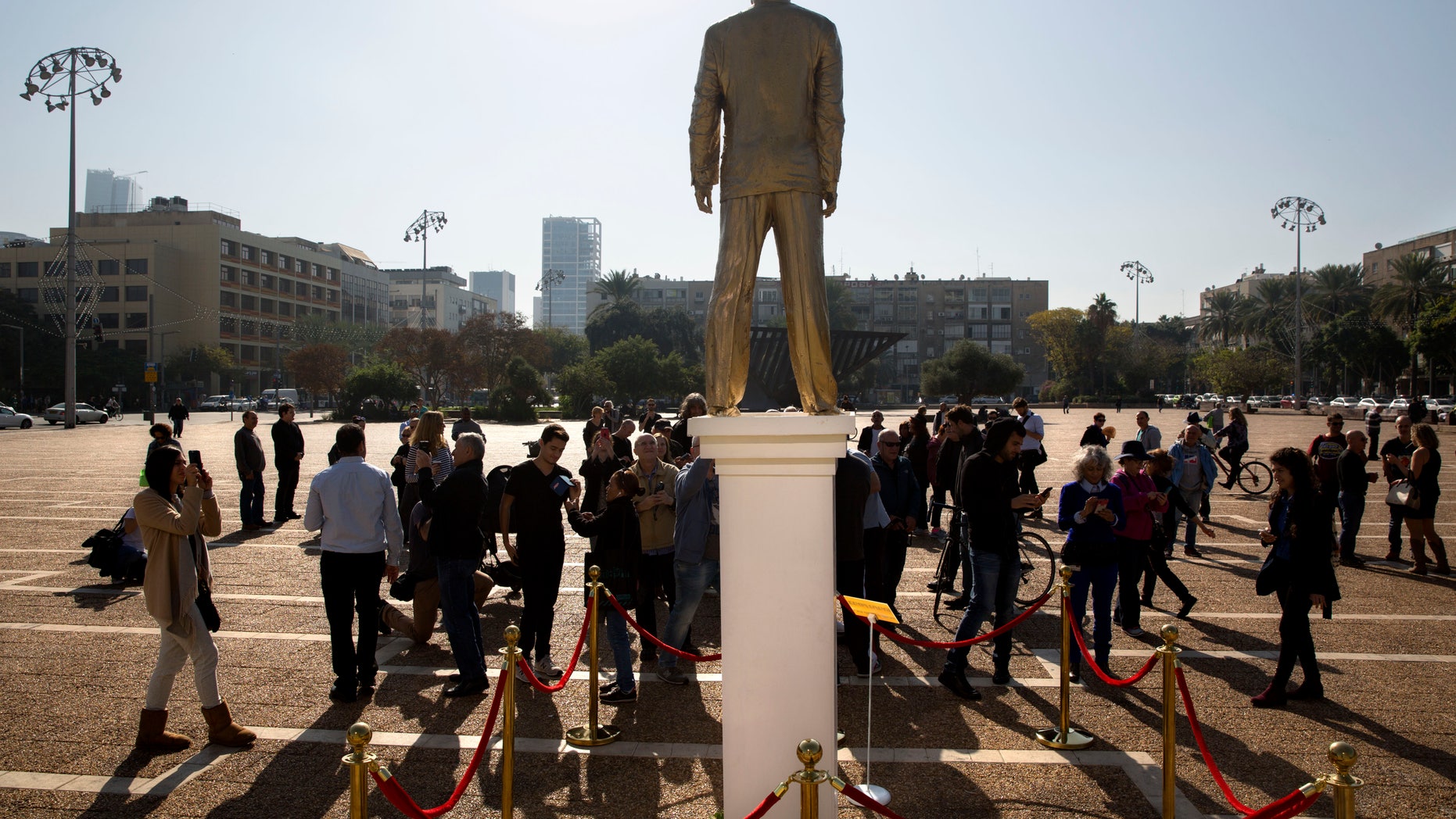 People watch a statue of Israeli Prime Minister Benjamin Netanyahu at the central square in Tel Aviv, Tuesday, Dec. 6.