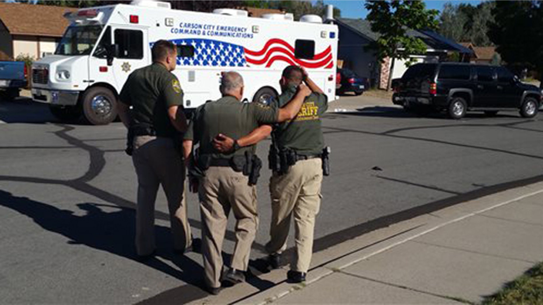 Aug. 15, 2015: Carson City Sheriff's Department deputies comfort each other outside the scene of a fatal shooting in Carson City, Nev., that left an officer and a suspect dead.