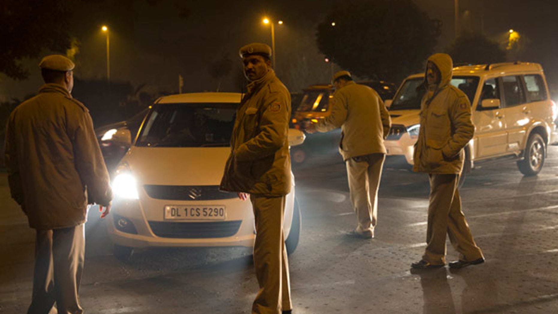 Jan. 1, 2016: Indian policemen check passing cars on the New Year's eve in New Delhi, India. (AP)
