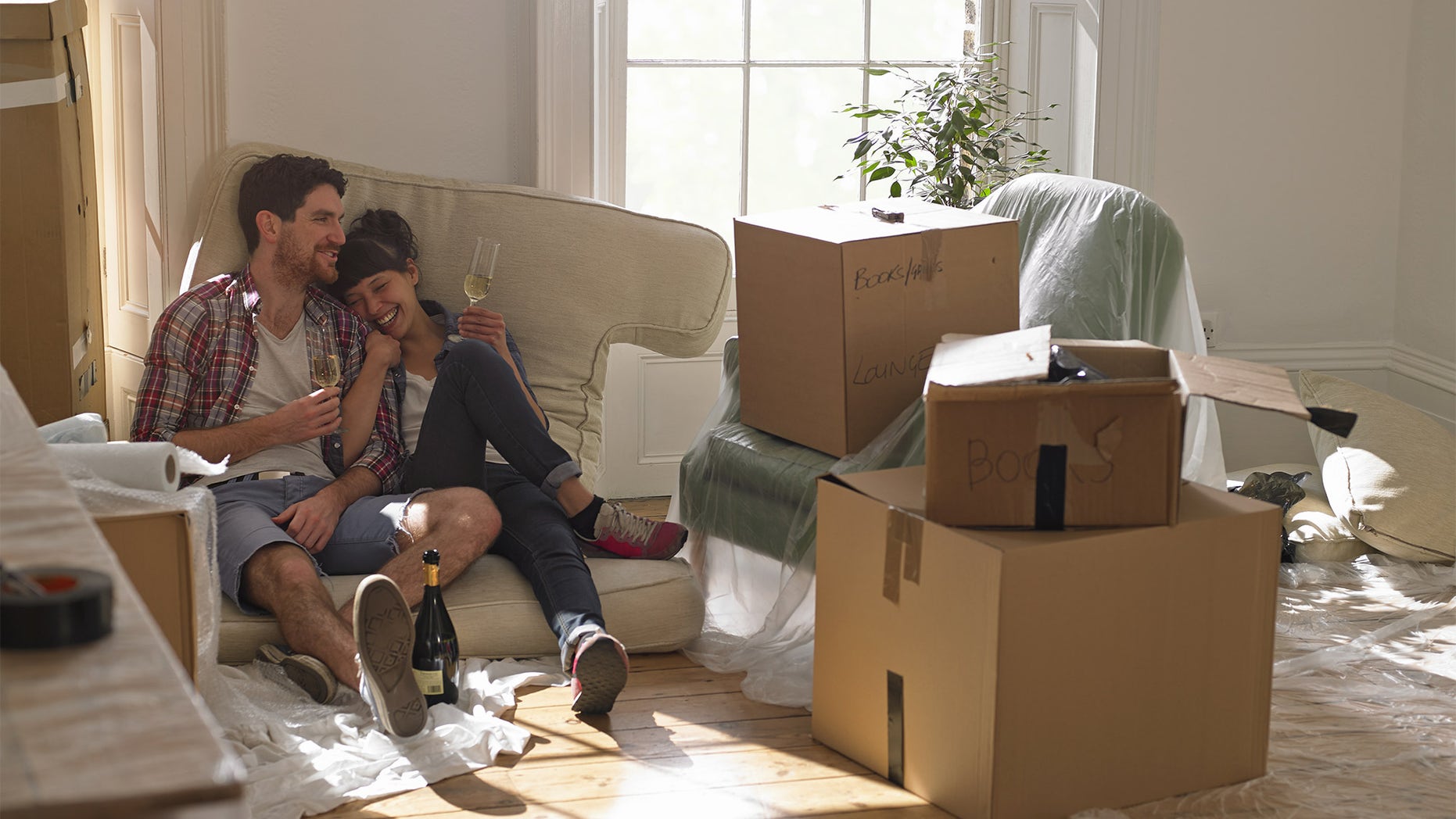 couple moving in to new house, drinking champagne