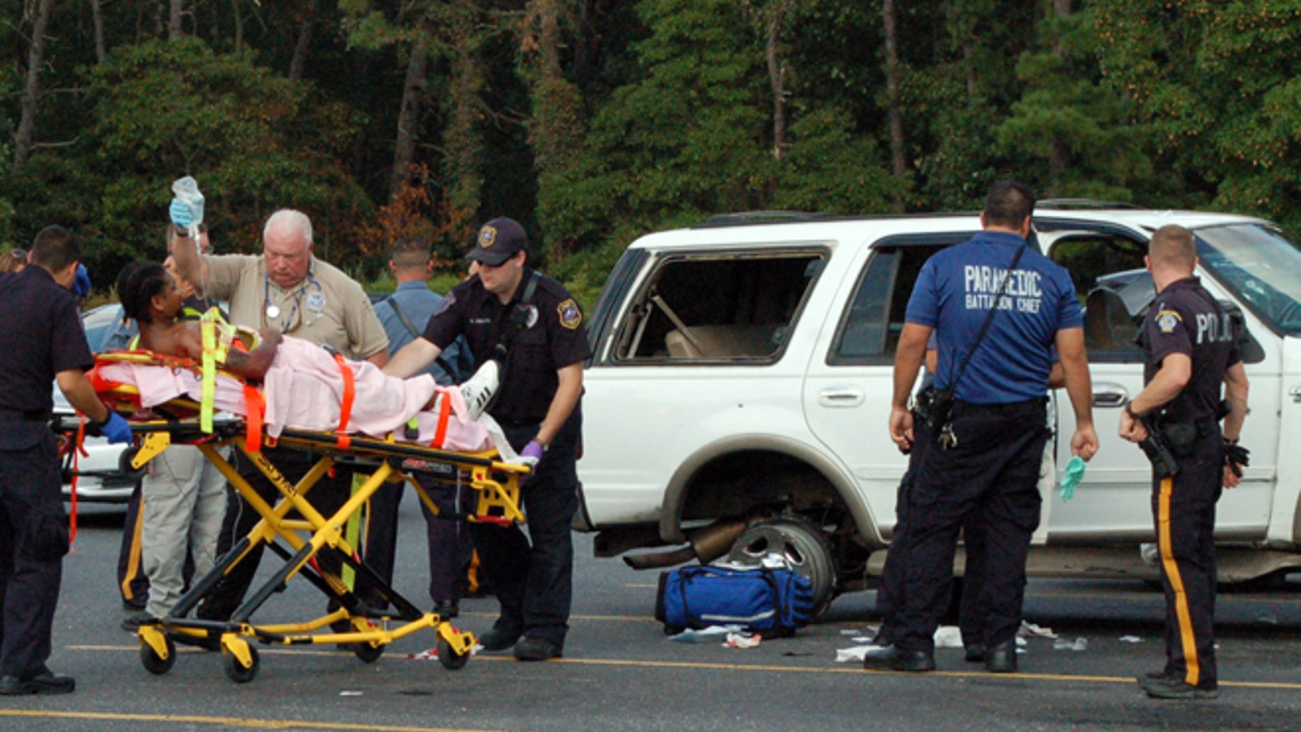 Emergency personnel attend an injured person as police investigate after a deadly shooting in Egg Harbor Township, N.J., Monday Aug. 29, 2016. A deadly shootout on a New Jersey highway left multiple injured.