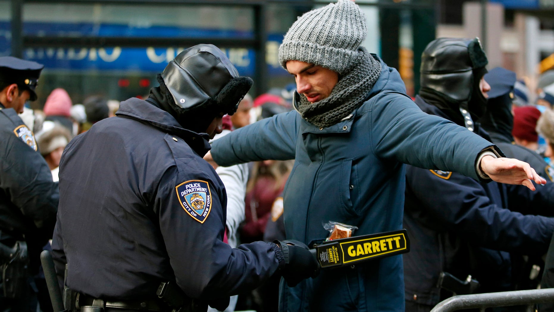 Dec. 31, 2014: A police officer checks a man entering a cordoned off area of Times Square on New Year's Eve in New York.