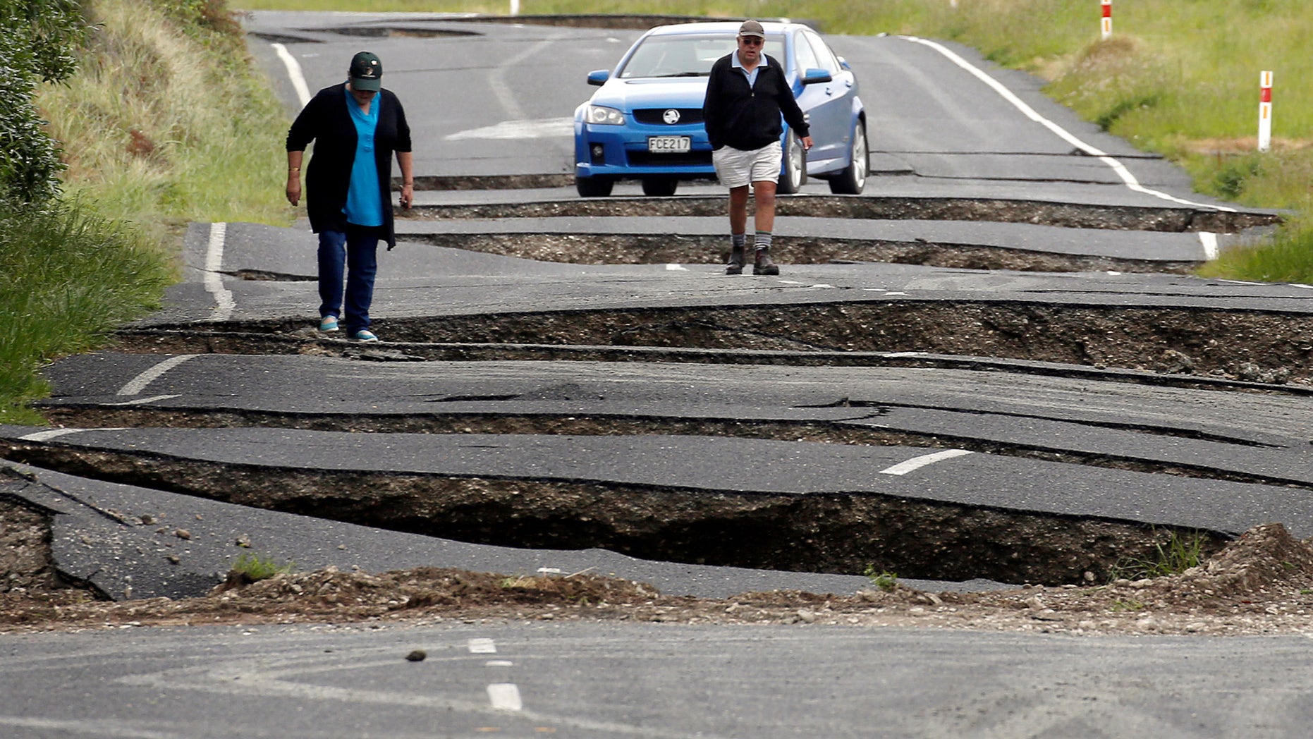 Local residents Chris and Viv Young look at damage caused by an earthquake, along State Highway One near the town of Ward, south of Blenheim on New Zealand's South Island, November 14, 2016. (REUTERS/Anthony Phelps)