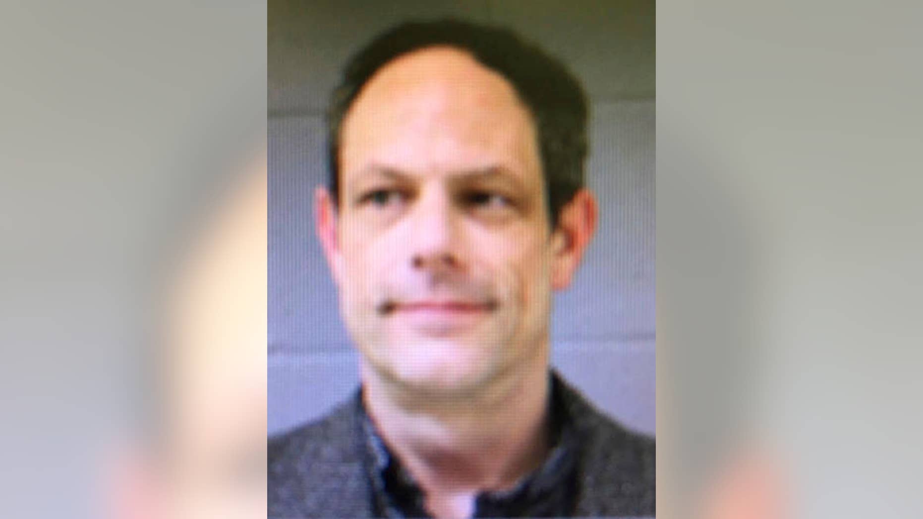 This booking photo released by the Newtown Police Department shows Jason Adams, arrested Wednesday, April 6, 2016, and charged with having a gun at the town's middle school. Adams, 46, a teacher at the school, was charged with possession of a weapon on school grounds, which is illegal in Connecticut. Police said he has a valid pistol permit. A gunman shot and killed 20 students and six educators at nearby Sandy Hook Elementary School in Newtown in December 2012. (Newtown Police Department via AP)