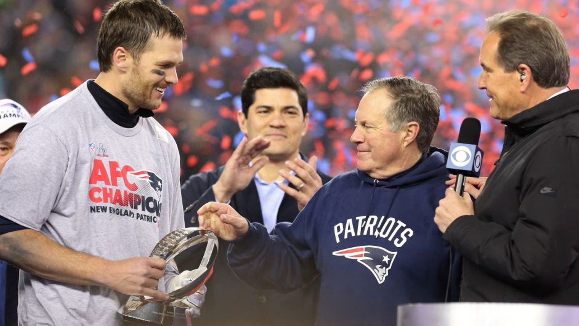 Jan 22, 2017; Foxborough, MA, USA; New England Patriots head coach Bill Belichick (M) hands the Lamar Hunt AFC championship trophy to Patriots quarterback Tom Brady (L) on the victory podium as CBS broadcaster Jim Nantz (R) looks on after the Patriots defeated the Pittsburgh Steelers in the 2017 AFC Championship Game at Gillette Stadium. Mandatory Credit: Geoff Burke-USA TODAY Sports