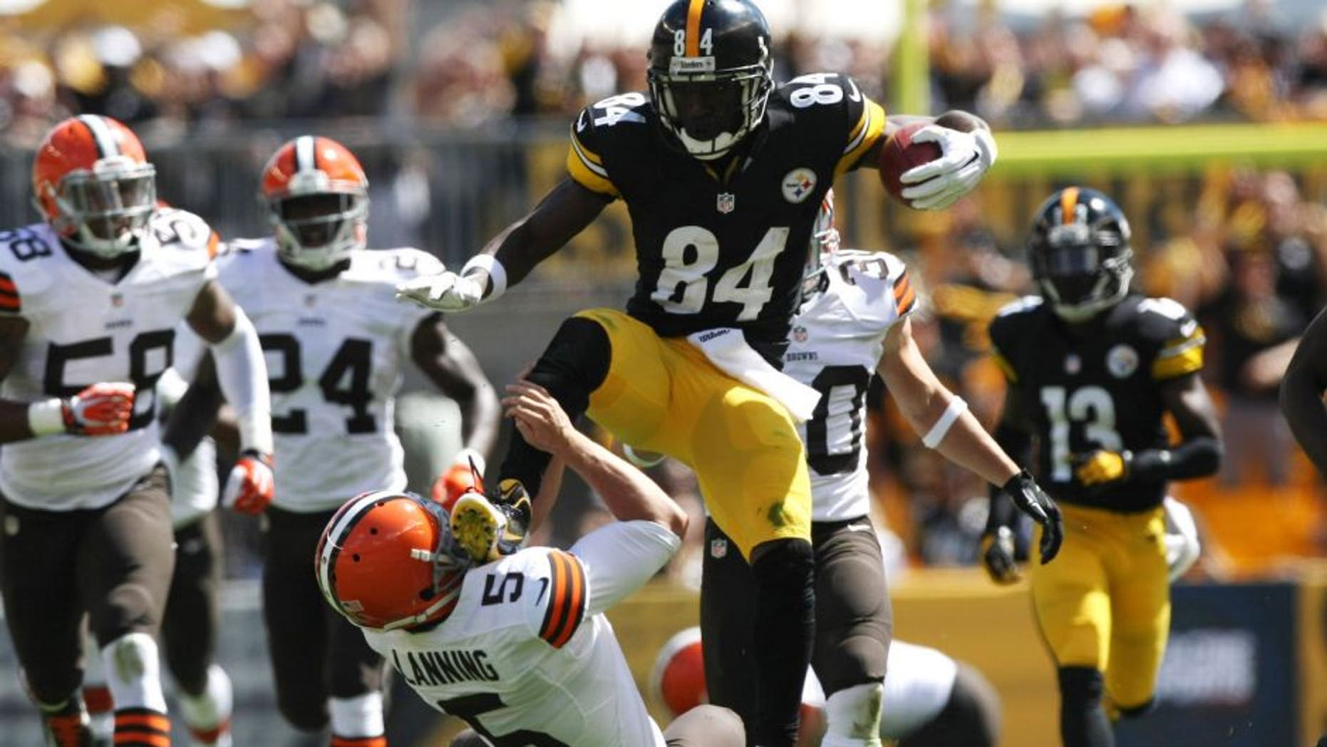 Sep 7, 2014; Pittsburgh, PA, USA; Pittsburgh Steelers wide receiver Antonio Brown (84) runs over Cleveland Browns punter Spencer Lanning (5) during the first half at Heinz Field. Brown was flagged on the play. Mandatory Credit: Jason Bridge-USA TODAY Sports