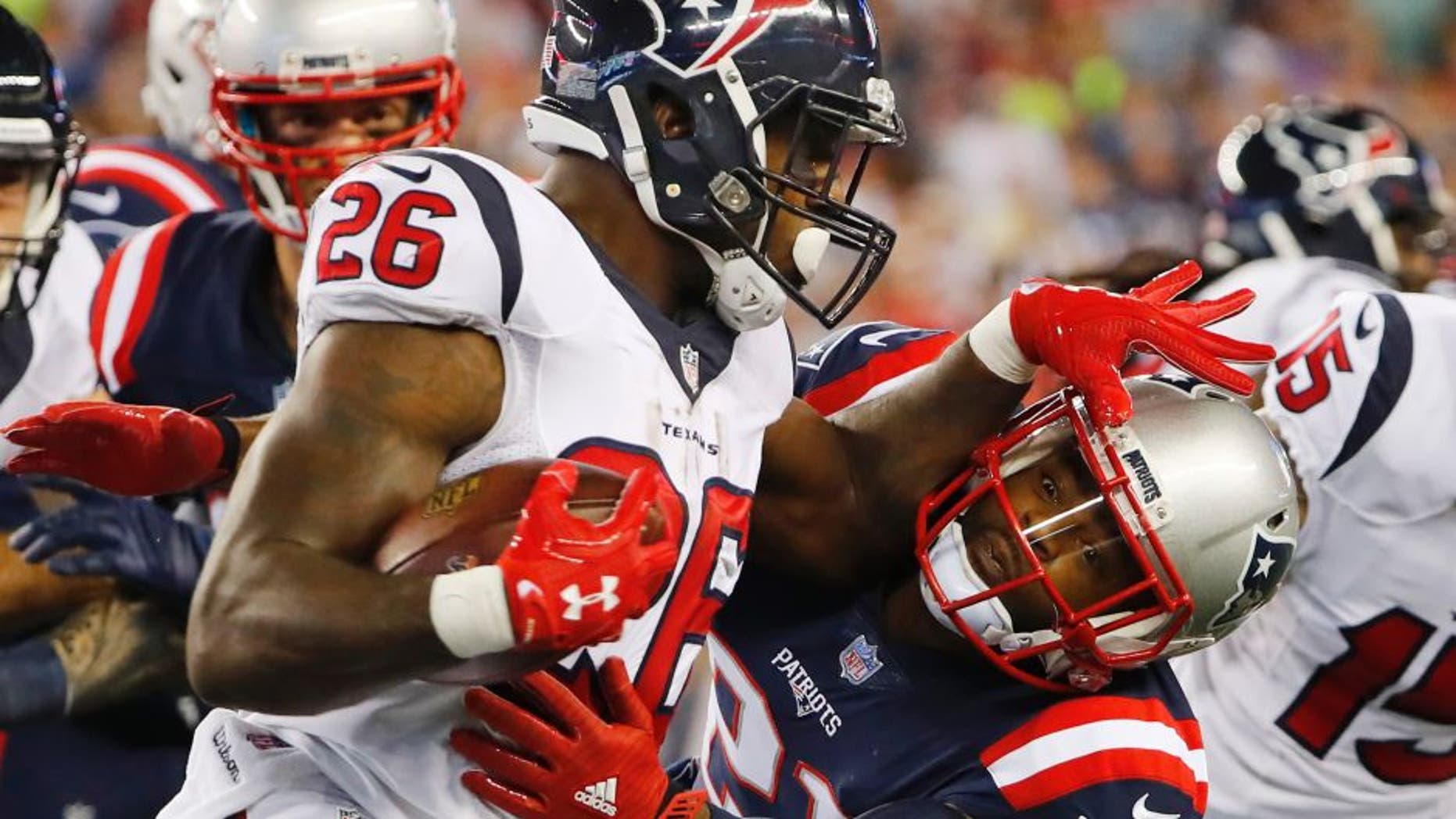 Sep 22, 2016; Foxborough, MA, USA; Houston Texans running back Lamar Miller (26) tries to push away New England Patriots cornerback Malcolm Butler (21) during the first half at Gillette Stadium. Mandatory Credit: Winslow Townson-USA TODAY Sports