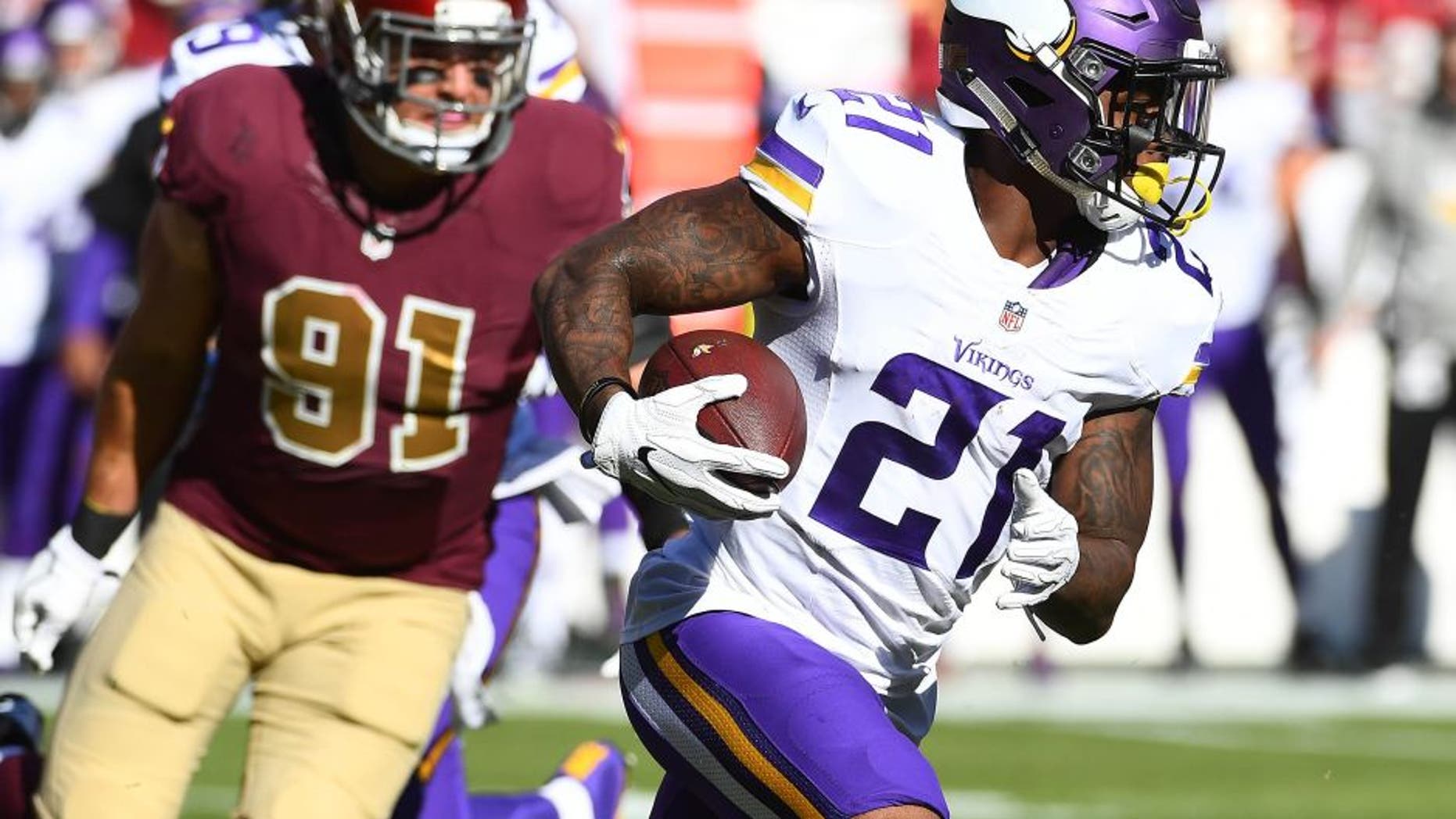 Nov 13, 2016; Landover, MD, USA; Minnesota Vikings running back Jerick McKinnon (21) runs the ball as Washington Redskins linebacker Ryan Kerrigan (91) looks on during the first half at FedEx Field. Mandatory Credit: Brad Mills-USA TODAY Sports