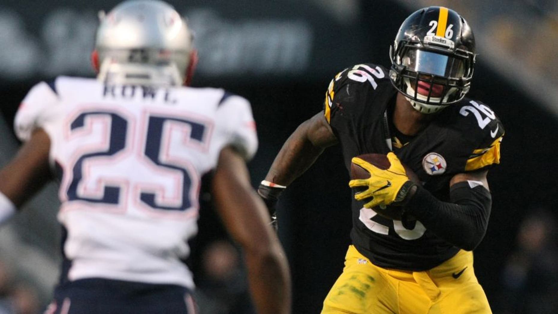 Oct 23, 2016; Pittsburgh, PA, USA; Pittsburgh Steelers running back Le'Veon Bell (26) runs the ball against New England Patriots defensive back Eric Rowe (25) during the second half at Heinz Field. The Patriots won 27-16. Mandatory Credit: Jason Bridge-USA TODAY Sports