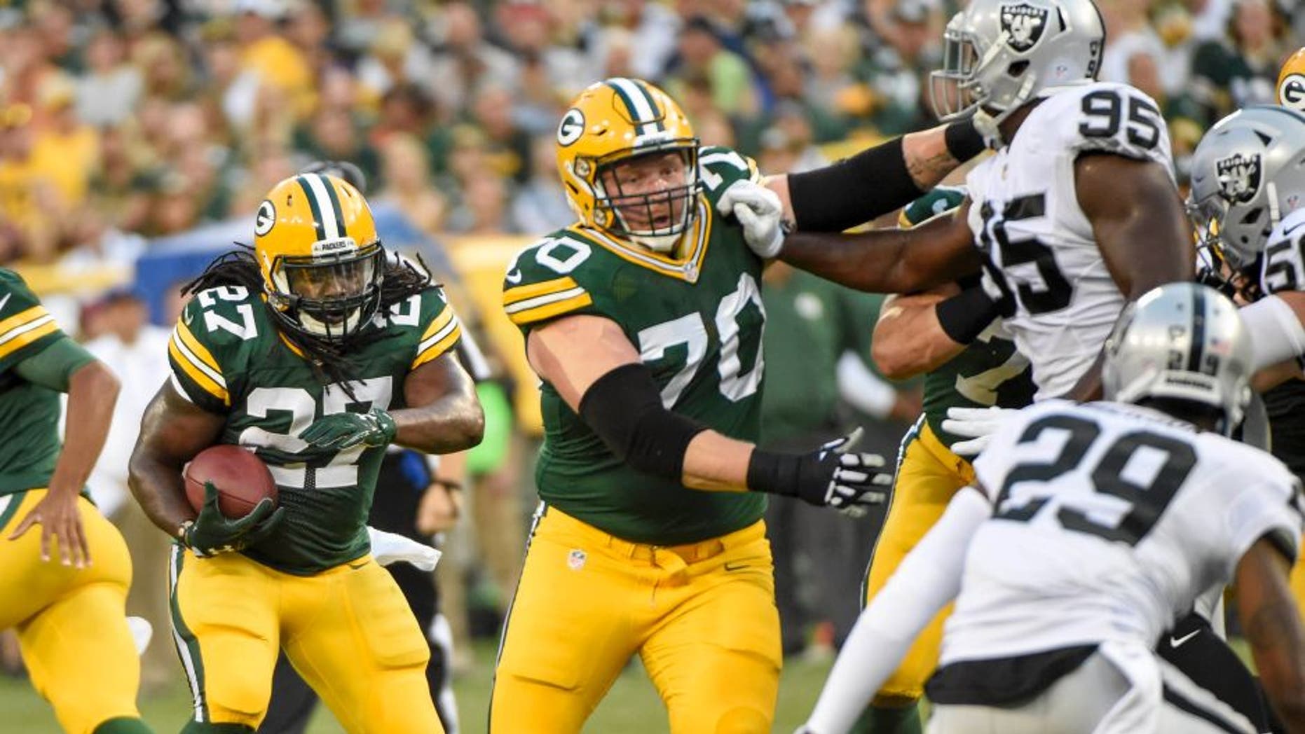 Aug 18, 2016; Green Bay, WI, USA; Green Bay Packers running back Eddie Lacy (27) follows a block by guard T.J. Lang (70) in the first quarter during the game against the Oakland Raiders at Lambeau Field. Mandatory Credit: Benny Sieu-USA TODAY Sports