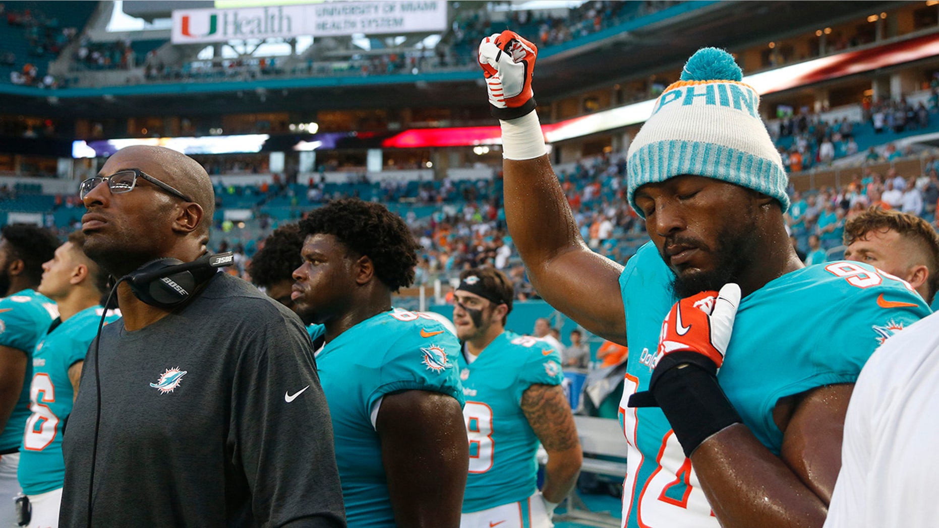 Miami Dolphins defensive end Robert Quinn (94) raises his right fist during the singing of the national anthem, before the team's NFL preseason football game against the Tampa Bay Buccaneers, Thursday, Aug. 9, 2018, in Miami Gardens, Fla.
