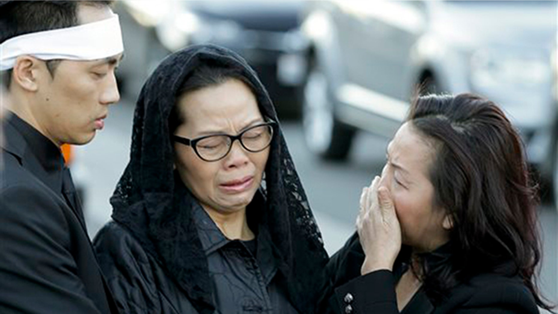Van Thanh Nguyen, center, arrives for her daughter Tin Nguyen's funeral on Saturday, Dec. 12, 2015 in Santa Ana, Calif. Nguyen died in the mass shootings in San Bernardino, Calif., on Dec. 2. (AP Photo/Chris Carlson)