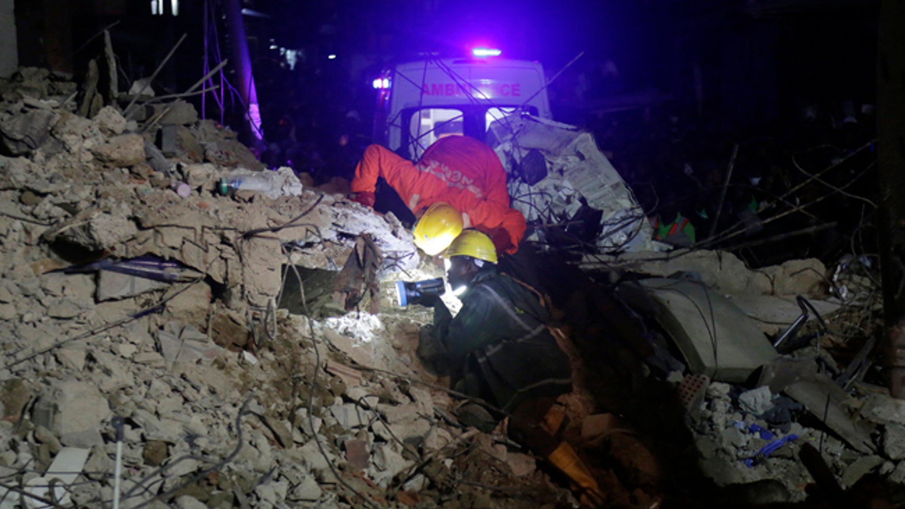Rescue workers use flashlights to search for survivors at the rubbles of a collapsed building in a densely populated neighborhood in Lagos, Nigeria. Tuesday, July 25, 2017. Rescue work is still ongoing. (AP Photo/Sunday Alamba)