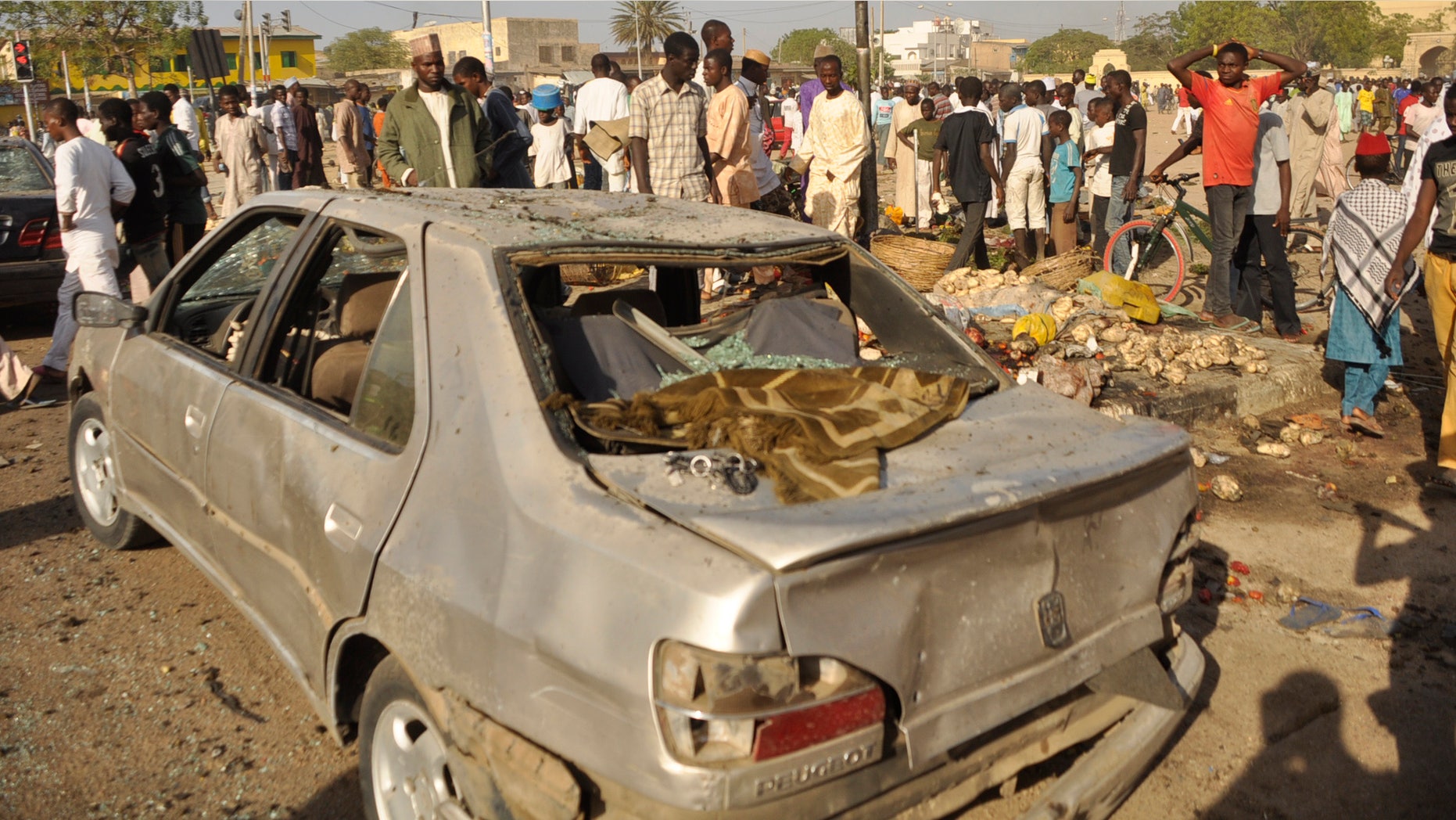 Nov. 28, 2014: People gather at the site of a bomb explosion in Kano, Nigeria
