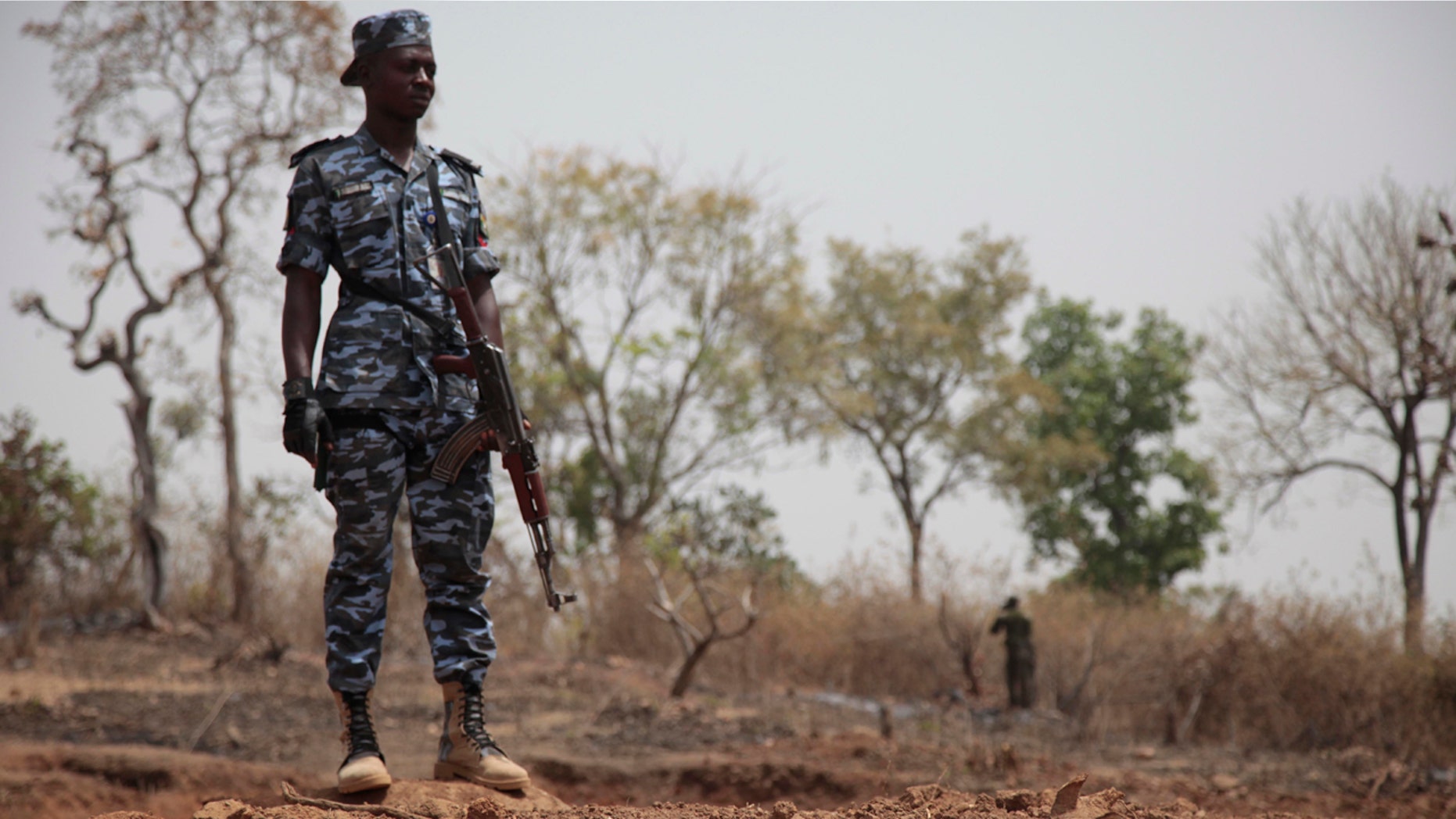 Security officers stand guard at the scene where a German archaeologists and his associate were kidnapped in Janjala Village, Nigeria. Friday, Feb. 24, 2017.