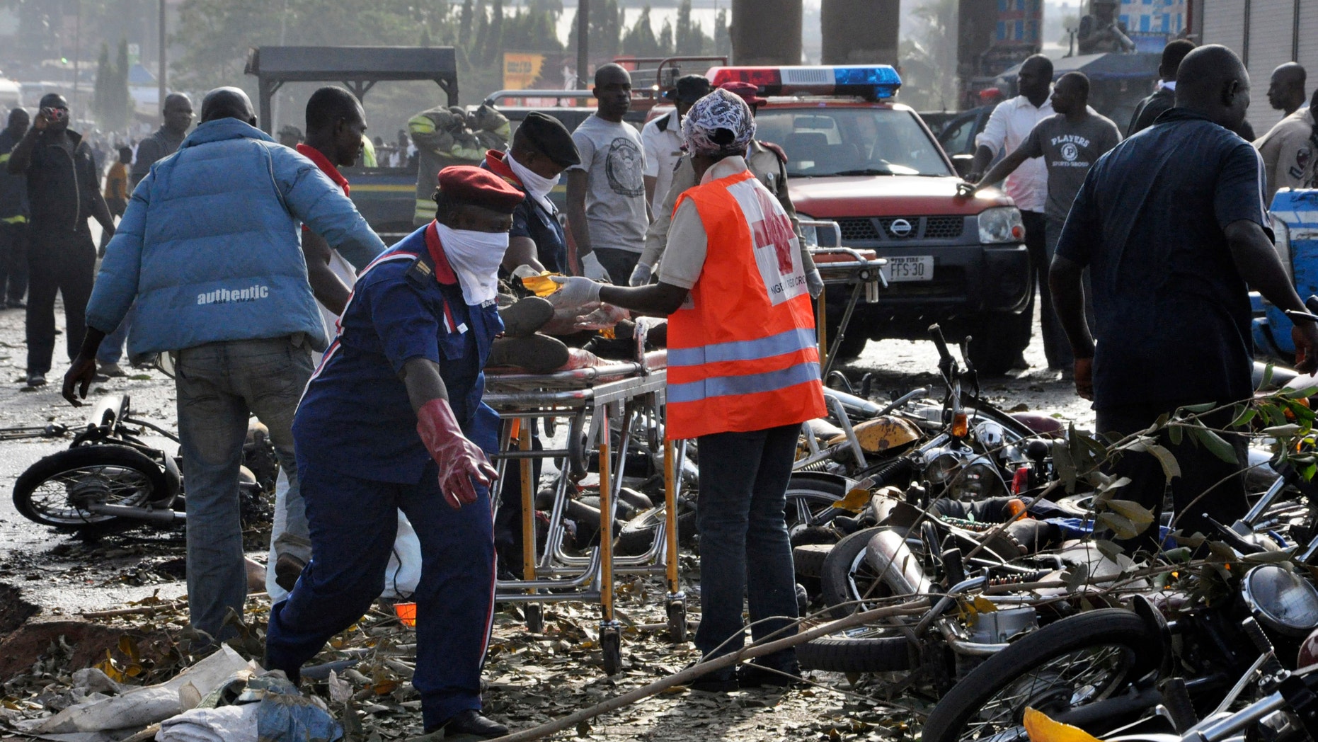 April 14, 2014: Rescue workers work to recover victims at the site of a blast at the Nyanya Motor Park, about 10 miles from the center of Abuja, Nigeria. An explosion blasted through a busy commuter bus station on the outskirts of Abuja as hundreds of people were traveling to work.