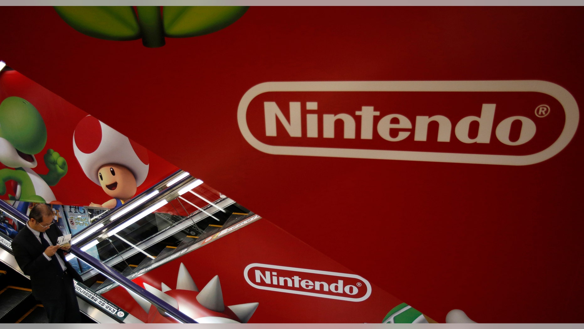 File photo: A shopper rides the escalator past Nintendo advertisements at an electronics retail store in Tokyo January 20, 2014. Shares in Nintendo Co Ltd tumbled by nearly a fifth on Monday after it warned of a third straight year of operating losses, heaping pressure on the creator of "Super Mario" to abandon its policy of not licensing its software to rivals. (REUTERS/Yuya Shino)