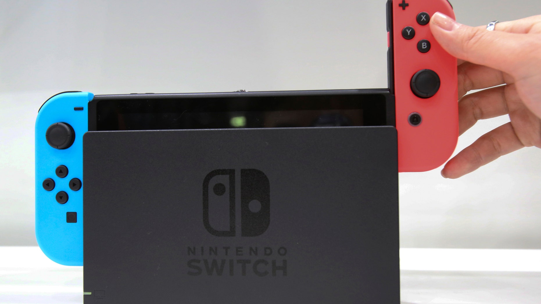 A model puts the controller on to the Nintendo Switch during a presentation event of the new Nintendo Switch in Tokyo, Friday, Jan. 13, 2017. (AP Photo/Koji Sasahara)