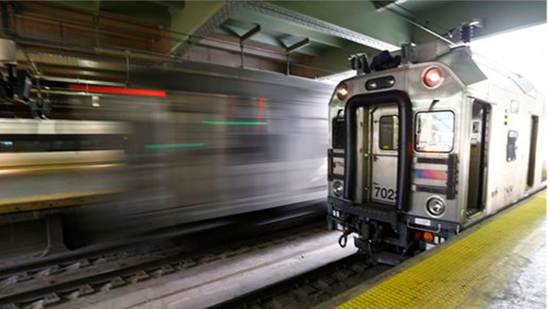 An NJ Transit train, left, rushes by as it leaves Newark Penn Station, Friday, March 11, 2016, in Newark, N.J. (AP Photo/Julio Cortez)