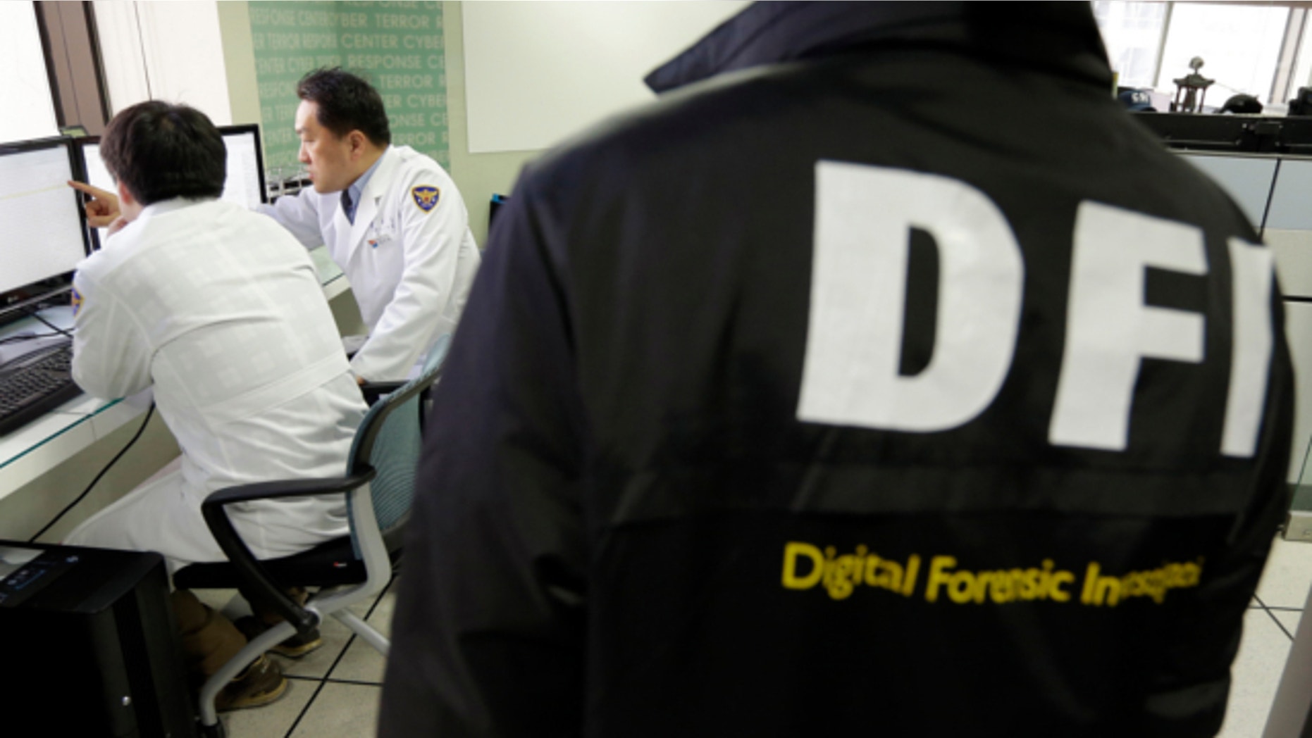 March 21, 2013: South Korean computer researchers, left, check the computer servers of Korean Broadcasting System (KBS) as a South Korean police officer from Digital Forensic Investigation watches at the Cyber Terror Response Center at the National Police Agency in Seoul, South Korea.