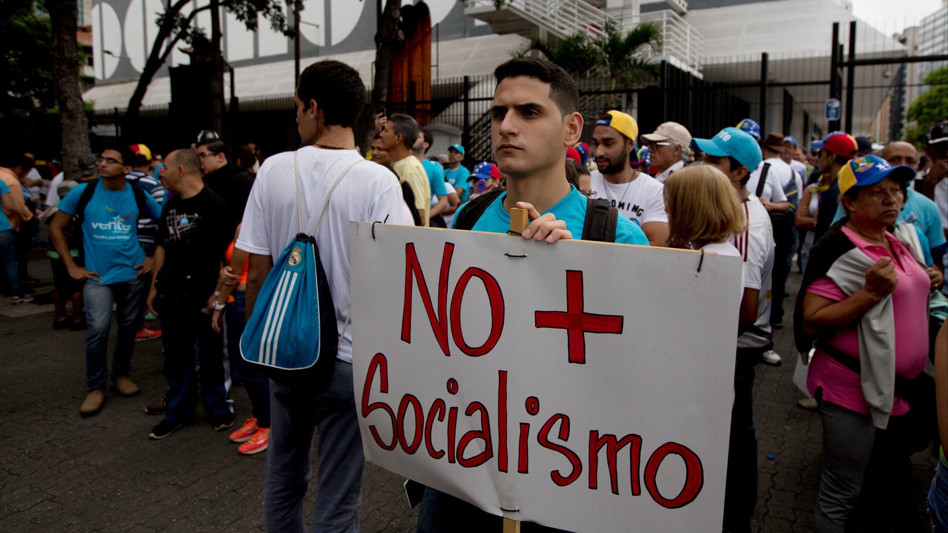 A young man holds poster that reads 'No more Socialism' in Caracas, Venezuela, Thursday, Sept 1, 2016.