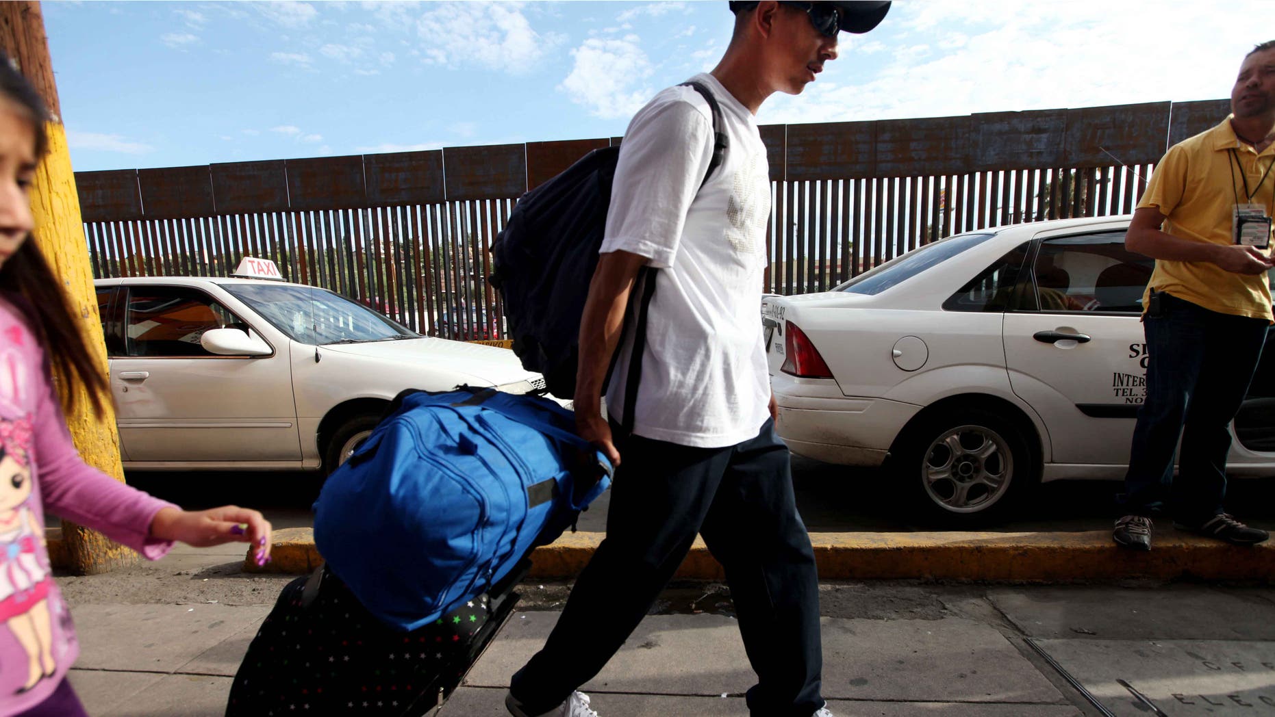NOGALES, MEXICO - JULY 7: A mexican national carts his luggage towards the U.S-Mexico border on July 7, 2012 in Nogales, Mexico. The president-elect of Mexico, Enrique Peña Nieto, stated that he wants to expand his country's drug-war partnership with the United States but that he would not support the presence of armed American agents in Mexico. (Photo by Sandy Huffaker/Getty Images)