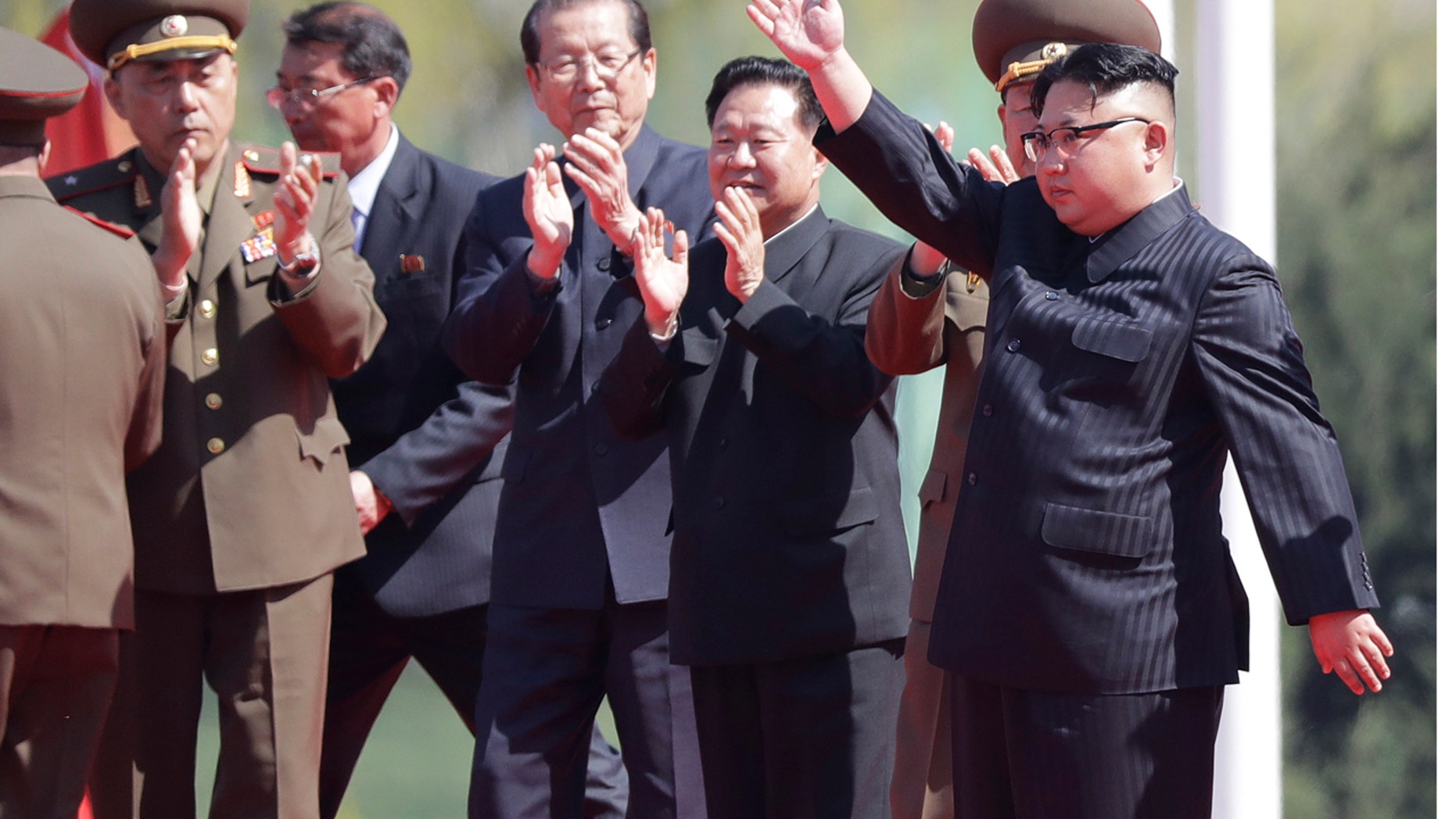 In this April 13, 2017 photo, North Korean leader Kim Jong Un, right, waves during the opening ceremony of the Ryomyong residential area, a collection of more than a dozen apartment buildings in Pyongyang, North Korea.