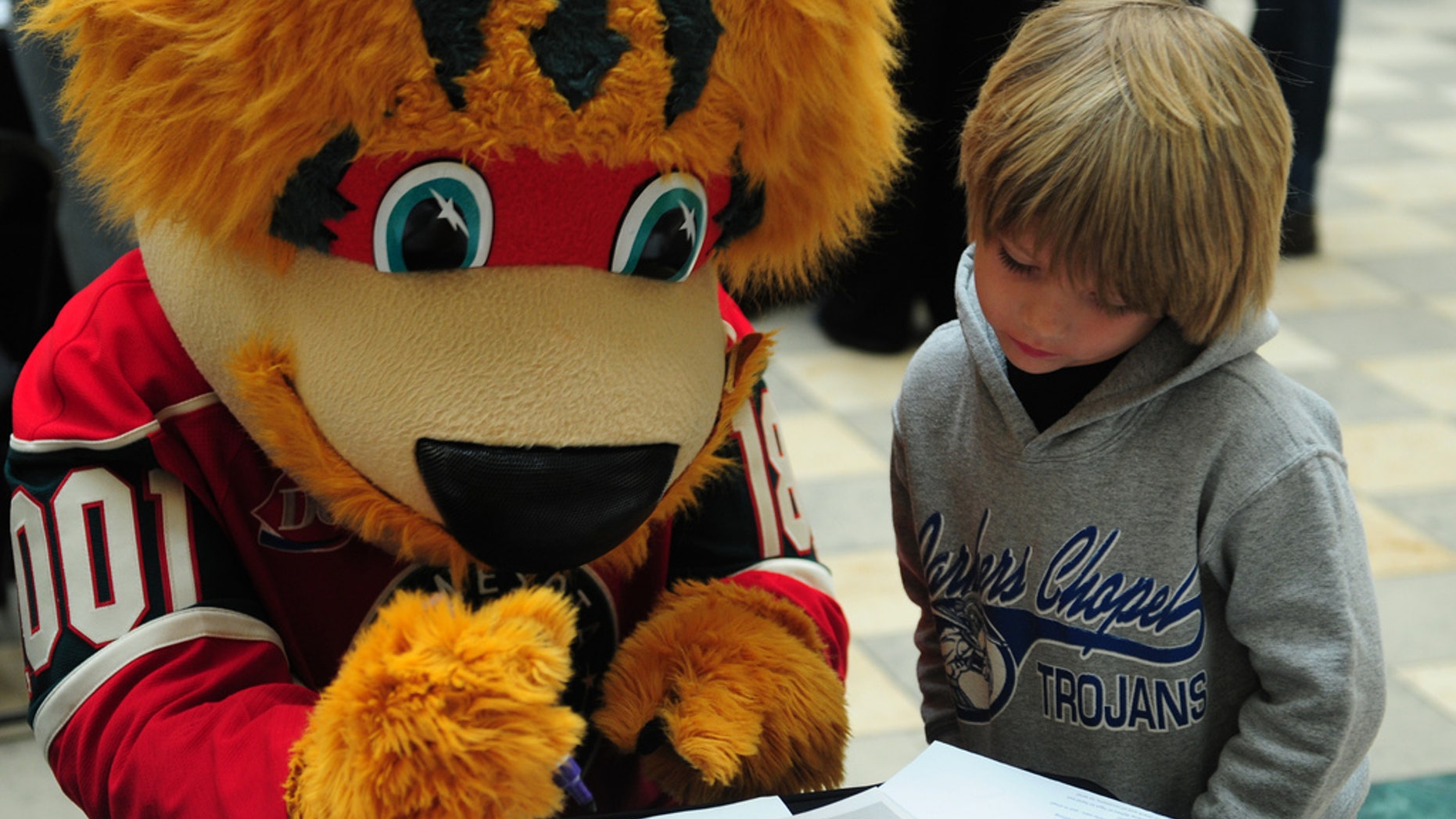 Nordy, the Minnesota Wild mascot, helps a youngster work on a word find during a post office event in 2013.