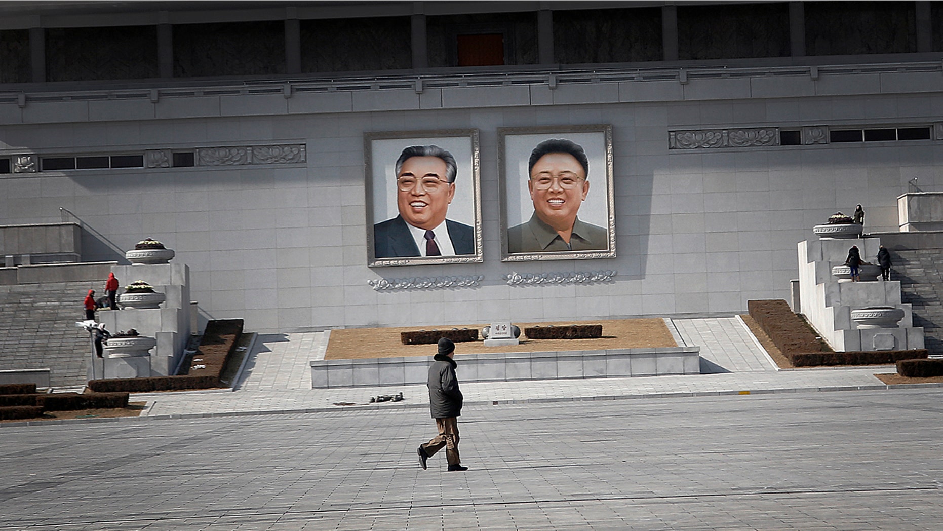 Feb. 14, 2016: A man walks past portraits of the late North Korean leaders Kim Il Sung and Kim Jong Il at Kim Il Sung Square in Pyongyang, North Korea (AP/Wong Maye-E)