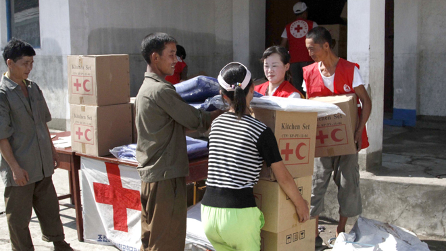 Aug. 4, 2012: Residents collect emergency goods, including kitchen sets and blankets, distributed by North Korean Red Cross officials in the flood-stricken city of Anju in South Phyongan Province, North Korea.