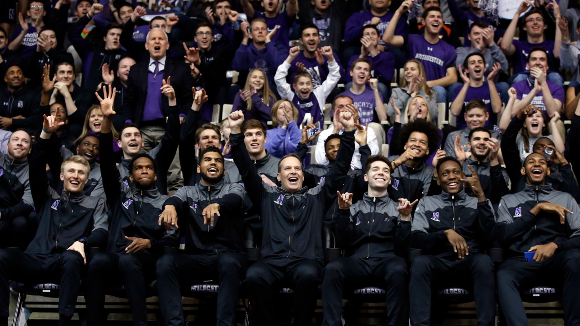 March 12, 2017: Northwestern head coach Chris Collins, center, and players react during a NCAA Division I Men's Basketball Tournament Selection Show watch party.