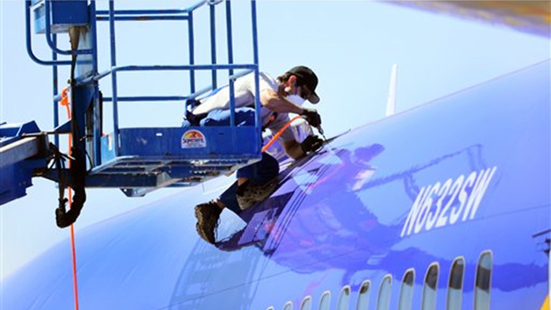 A member of the National Transportation Safety Board investigating the emergency landing of Southwest Airlines flight 812 cuts away a portion of the plane's fuselage on April 3 in Yuma, Ariz.