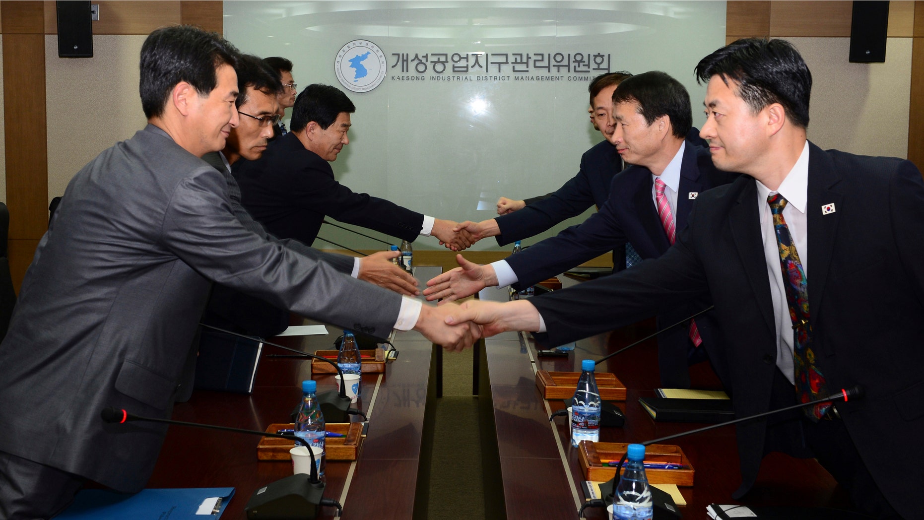 In this photo released by Unification Ministry, South Korean delegates, right, shake hands with their North Korean counterparts at the start of a meeting at Kaesong Industrial District Management Committee in Kaesong, North Korea, Wednesday, Sept. 11, 2013.