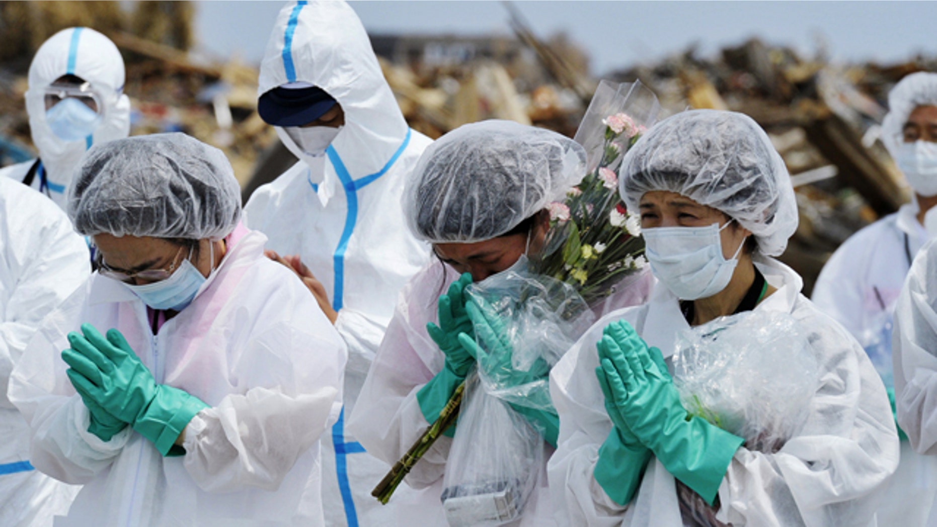 May 26: Residents pray in front of a makeshift incense stand on Thursday in Namie, northeastern Japan. Evacuees returned the area their houses used to stand before the March 11 earthquake and tsunami, inside the 12-mile exclusive zone around the crippled Fukushima Dai-ichi nuclear power plant. (AP/Kyodo News)