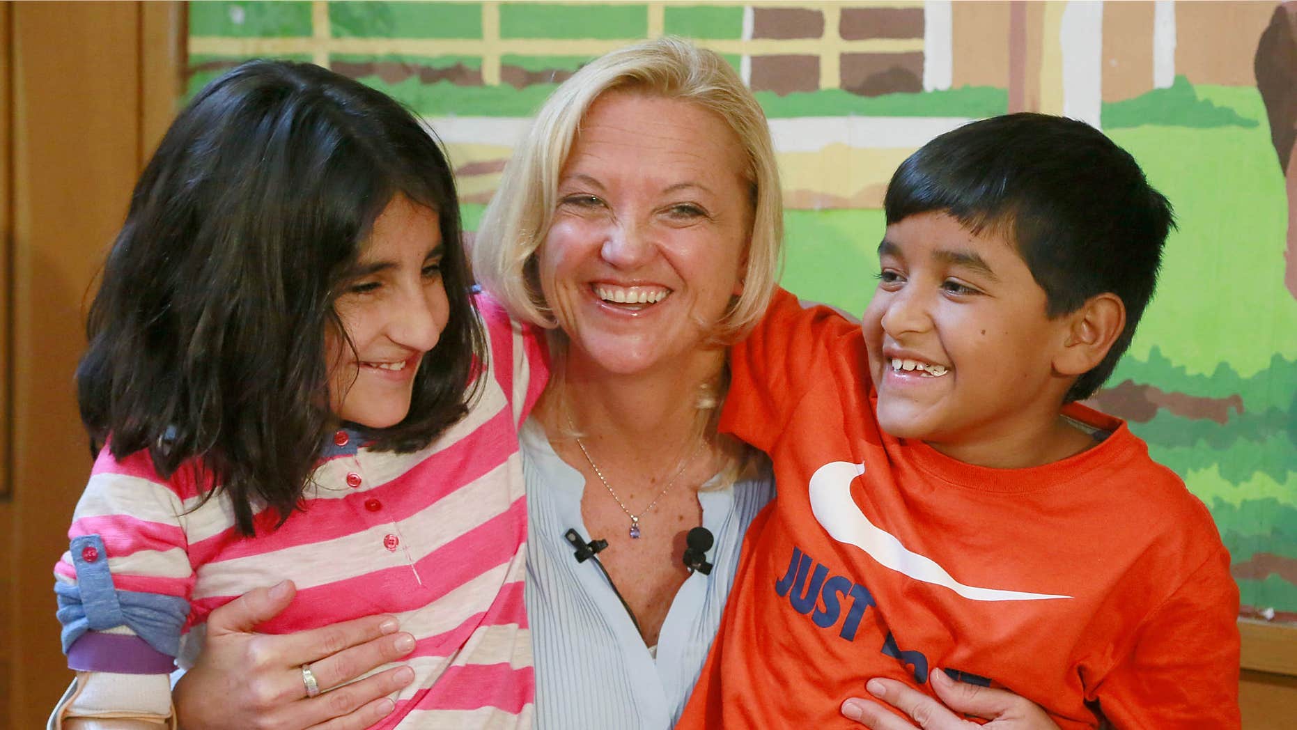 March 27, 2015: Lynette Austin, known as "Captain Sam," poses with war victims, Shah Bibi Tarakhail, left, and Abdul Wahid, during a media event at Shriners Hospitals for Children in Los Angeles.