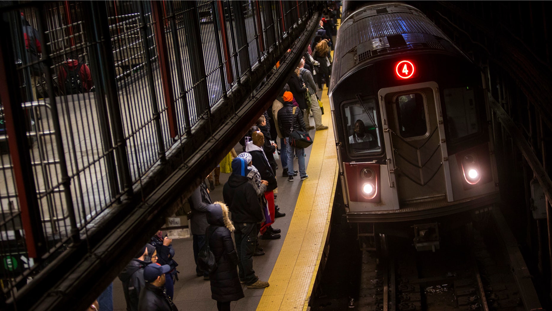 Commuters wait to ride New York City Subway in New York, December 12, 2013.