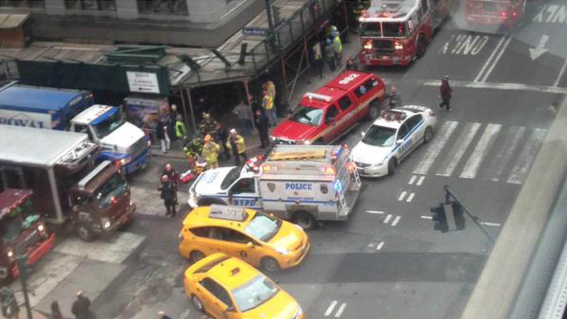 In this photo provided by Kaitlyn Ford, emergency personnel work the scene where authorities said four construction workers suffered serious injuries in a partial wall collapse inside a commercial building near Grand Central Terminal, in New York.