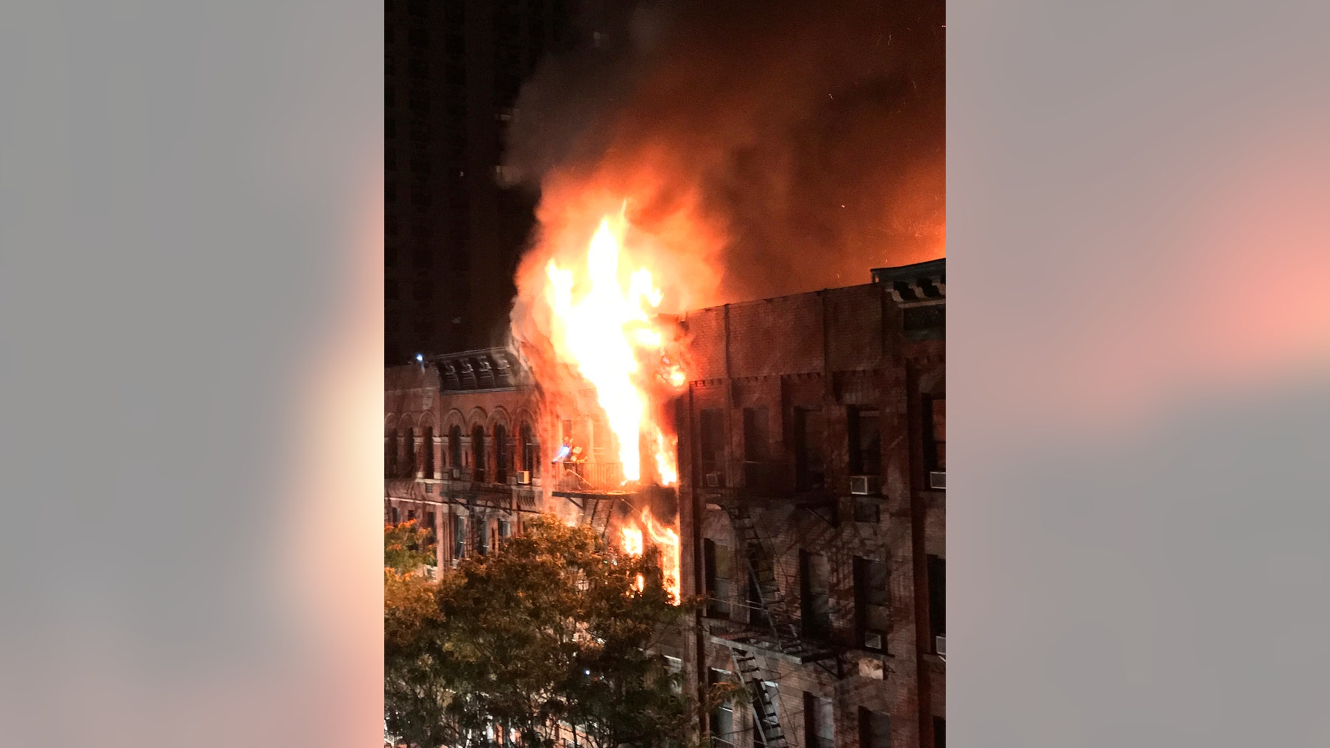 Flames rise from an apartment building fire on the Upper East Side in New York on Thursday, Oct. 27, 2016. The flames quickly spread throughout the building and were shooting out the roof at one point, sending burning embers onto nearby buildings. (Matt Bonaccorso via AP)