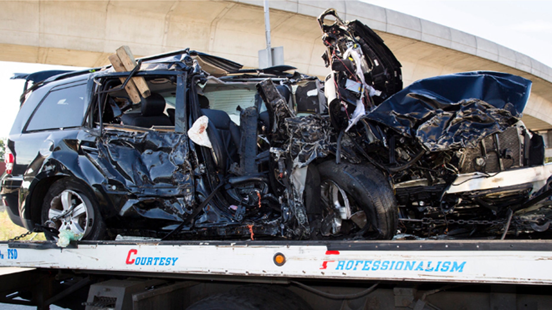 July 22, 2012: Authorities clear an automobile involved in a single-vehicle crash that took the lives of five people, including two children, near the Van Wyck Expressway in the Queens borough of New York.