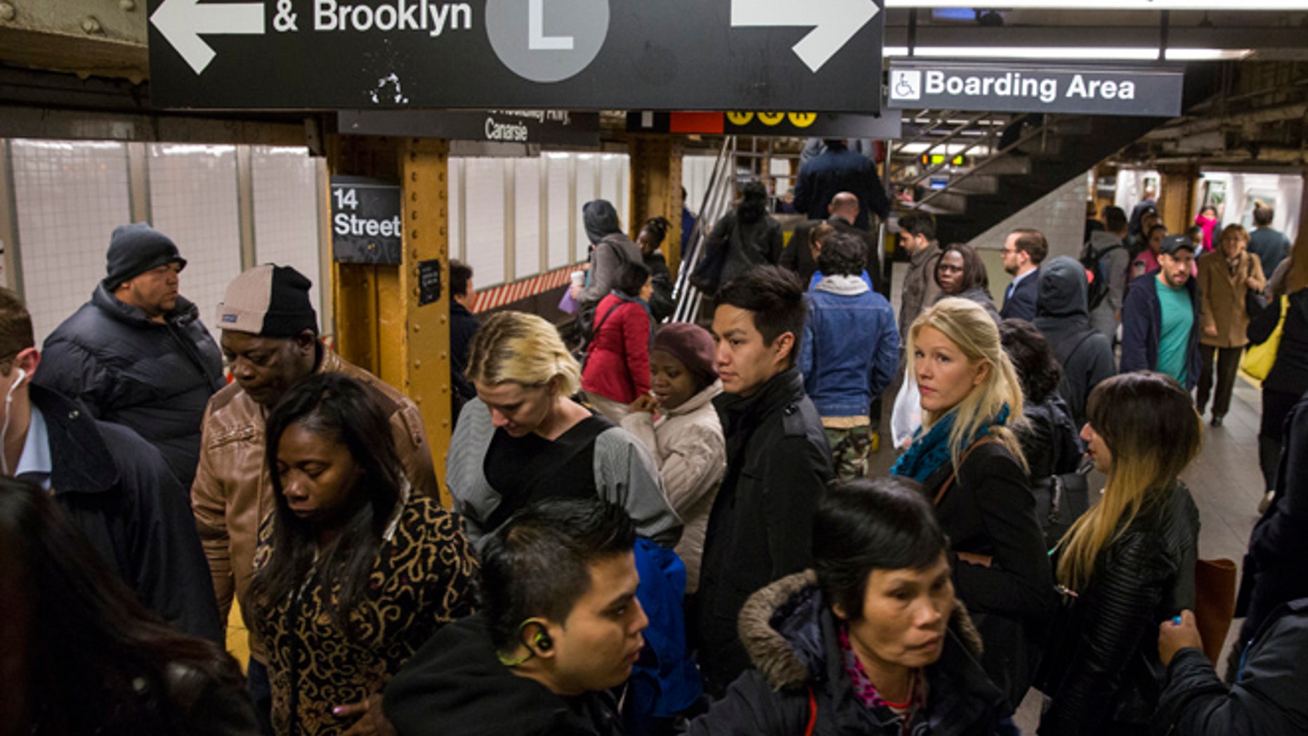 FILE Commuters depart an L train during the morning commute.