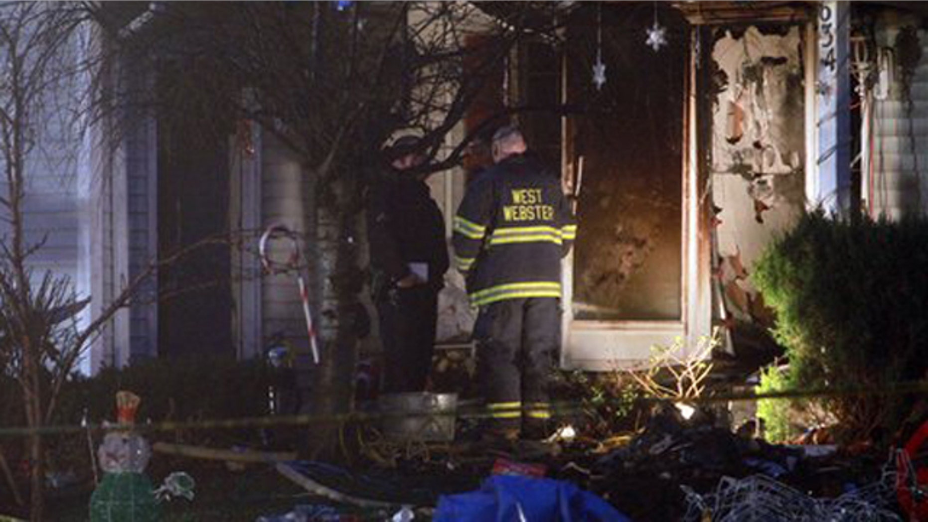 Emergency personnel investigate outside a home after a fire in Webster, NY on Wednesday, Dec. 7, 2011.
