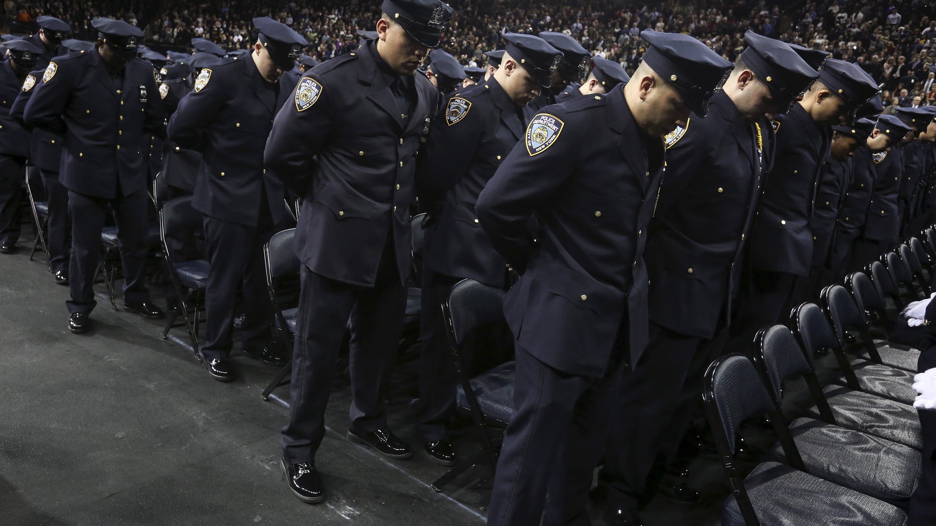 Dec. 29, 2015- Newly inducted New York Police officers observe a solemn moment at a graduation ceremony at Madison Square Garden. (REUTERS)