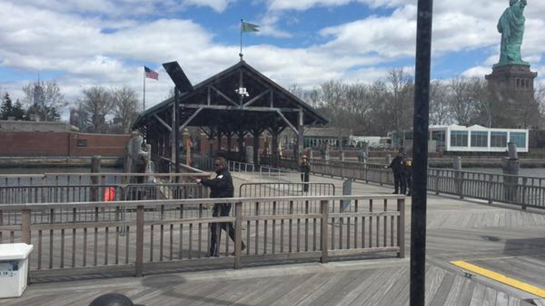 This photo, taken by tourist Rick Borgmeyer, of St. Louis, Mo., shows New York City Police officers inspecting the perimeter of Liberty Island Friday after reports of a suspicious package.