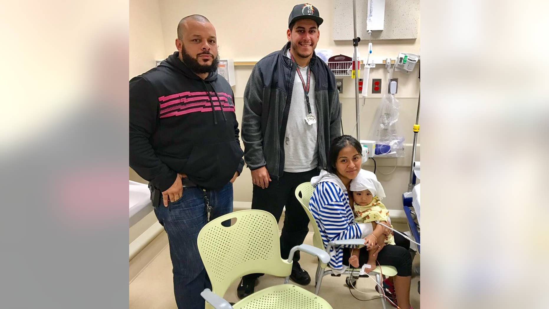 NYPD officers Felix Baez and Giovanni Laguna stand with Lilina Benigno and her daughter, Ashley Dolores.