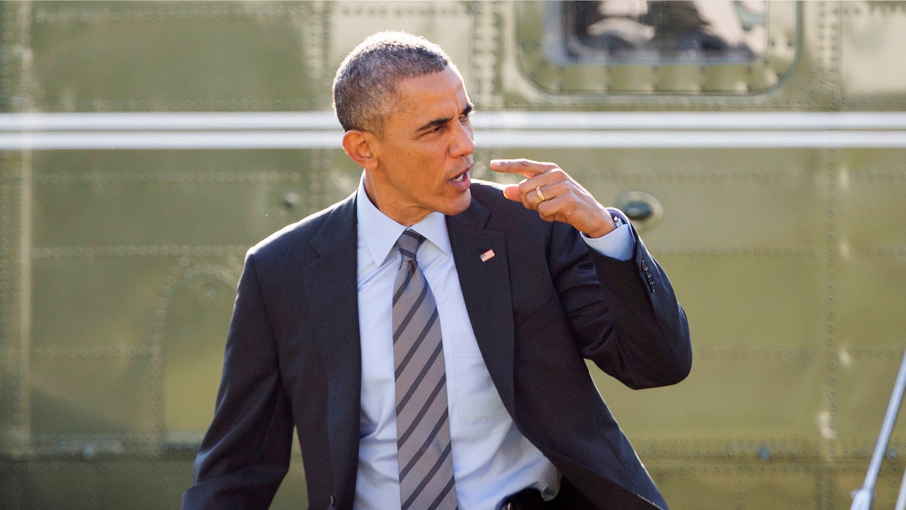 Nov. 21, 2014: President Barack Obama signals to his aides and staff that he will return to the White House because he forgot something before his departure on Marine One helicopter