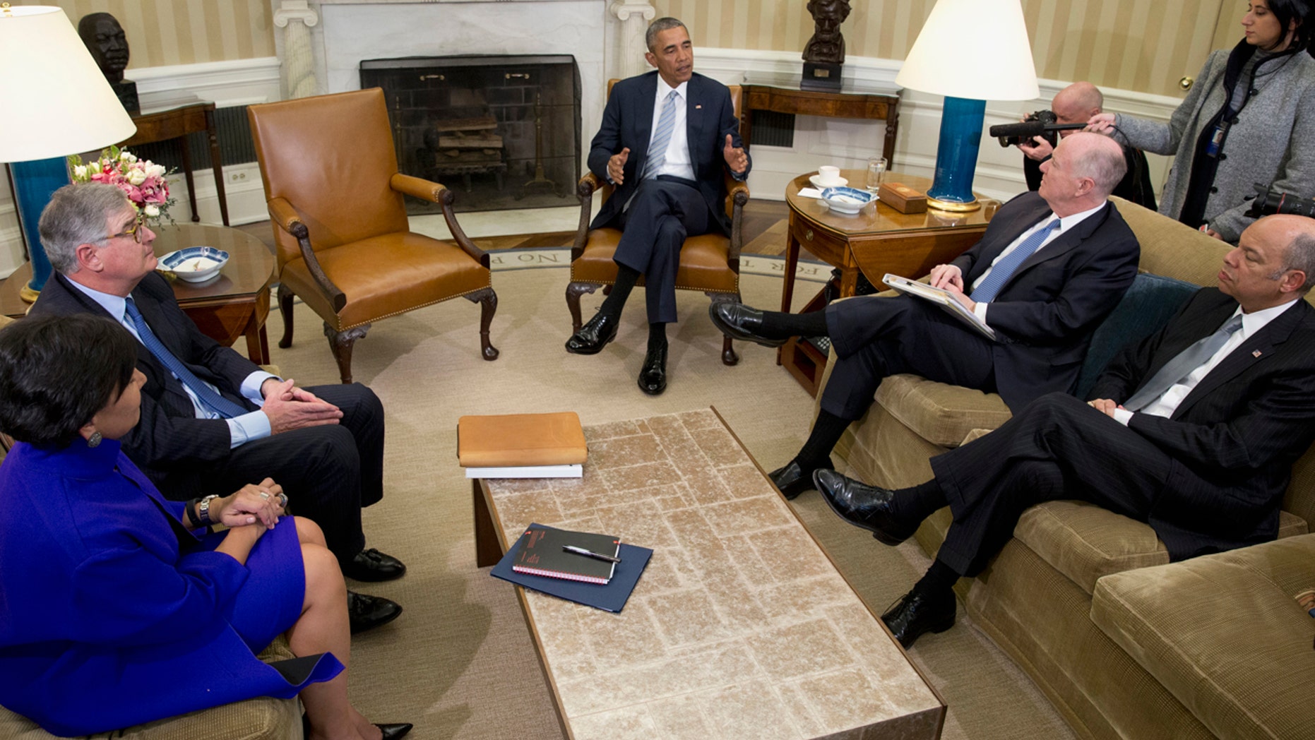 FILE - In this Feb. 17, 2016, file photo, President Barack Obama, joined by from left, Commerce Secretary Penny Pritzker, former IBM CEO Sam Palmisano, former National Security Adviser Tom Donilon, and Homeland Security Secretary Jeh Johnson, talks to media in the Oval Office of the White House, in Washington.