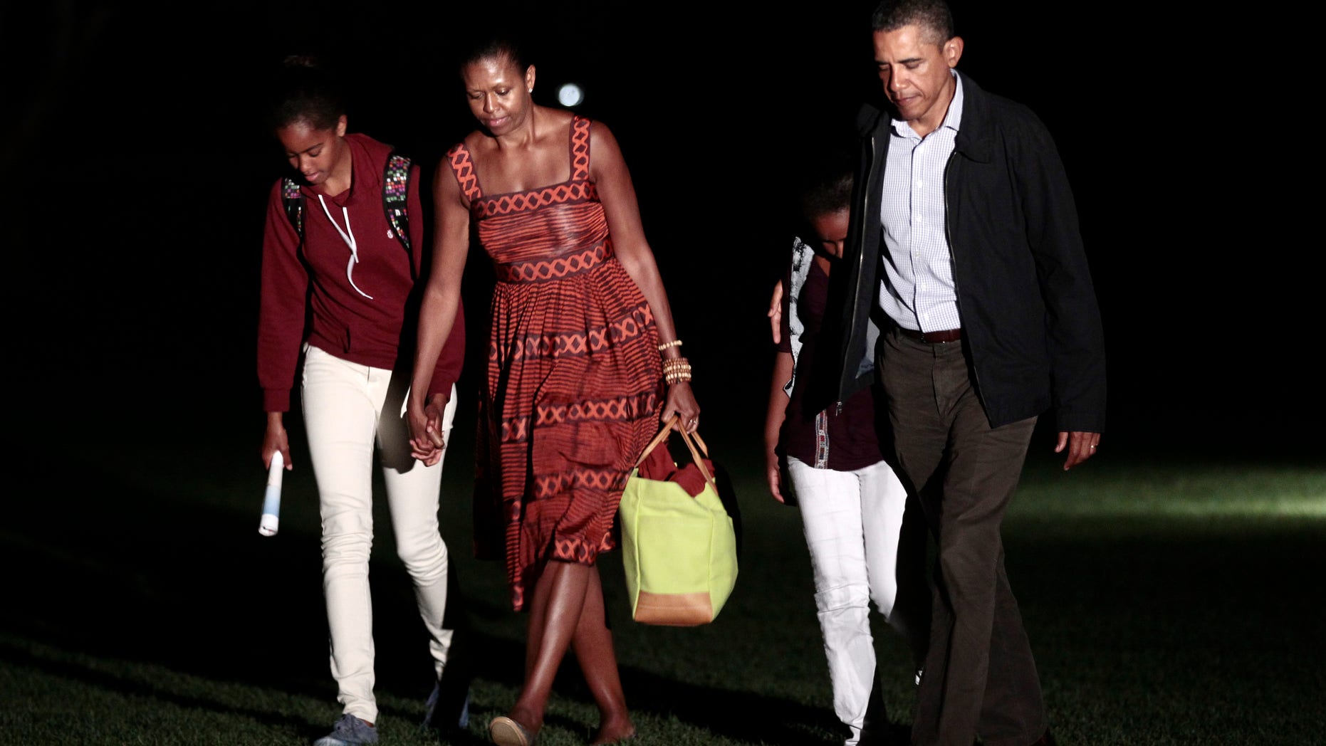 President Obama, first lady Michelle Obama and their daughters Sasha and Malia, far left, walk across the South Lawn of the White House in Washington, Friday, Aug., 26, 2011, after a family vacation on Martha's Vineyard.