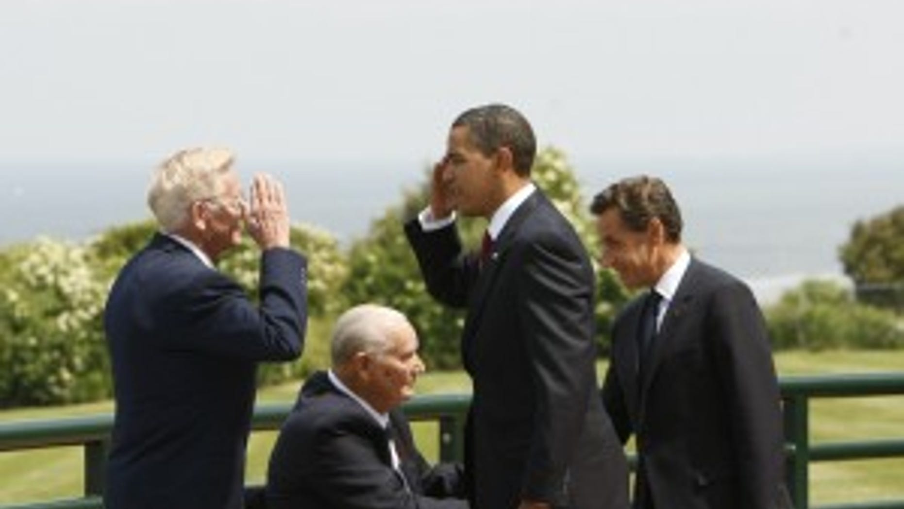 President Barack Obama returns a salute from D-Day veteran Clyde Combs, of Houston, left, as he arrives to participate in the 65th anniversary ceremony D-Day at Normandy American Cemetery and Memorial in Western France, Saturday, June 6, 2009. French President Nicolas Sarkozy is at right greeting D-Day veteran Ben Franklin of Knoxville, Tenn. (AP Photo)