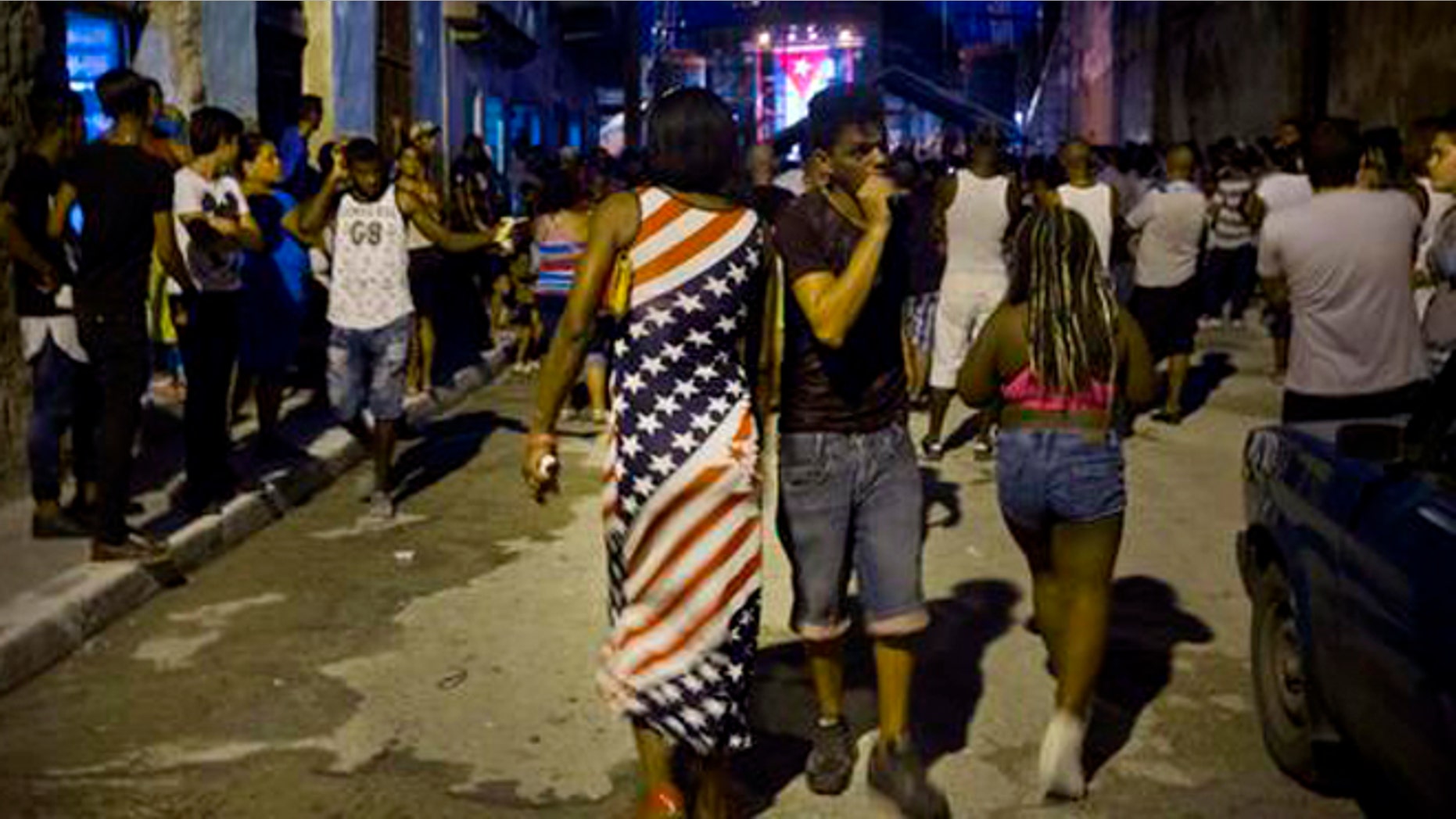 A woman wearing a dress with a U.S. flag motif walks to a concert by Silvio Rodriguez in Guanabacoa on the outskirts of Havana, Cuba, Friday, Sept. 9, 2016. President Barack Obama's easing of the U.S. trade embargo on Cuba has had virtually no positive effect on the island's economy, Cuba's top diplomat asserted Friday. (AP Photo/Ramon Espinosa)