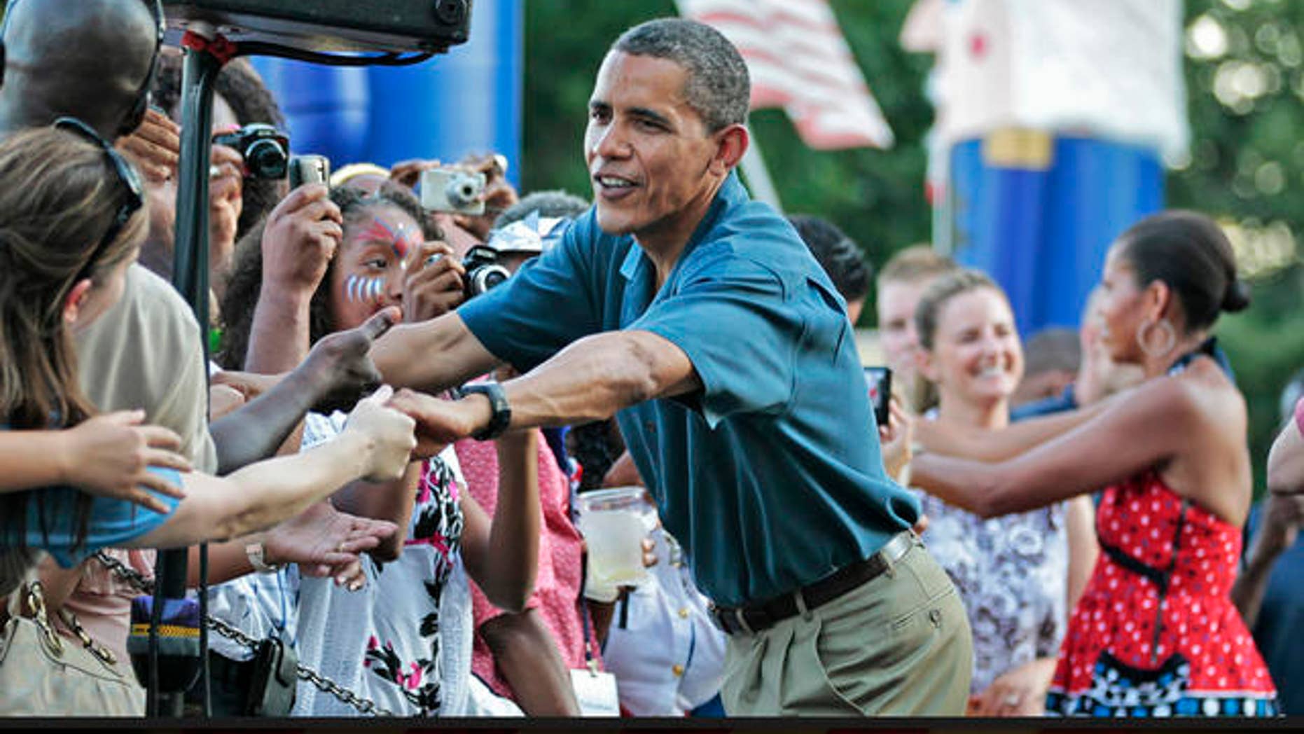 FILE: In this July 4, 2010, photo, President Obama and first lady Michelle Obama greet members of the United States Armed Forces and their families at the Independence Day celebration on the White House's South Lawn.